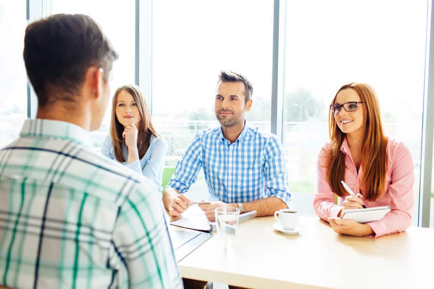 Recruitment. Three corporate people Interview young man