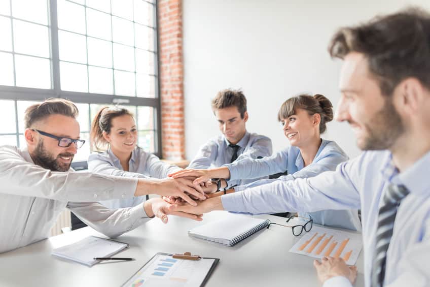 Close up top view of young business people putting their hands together. Stack of hands. Unity and teamwork concept.