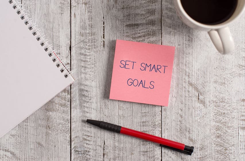 Handwritten text on sticky note Set Smart Goals.