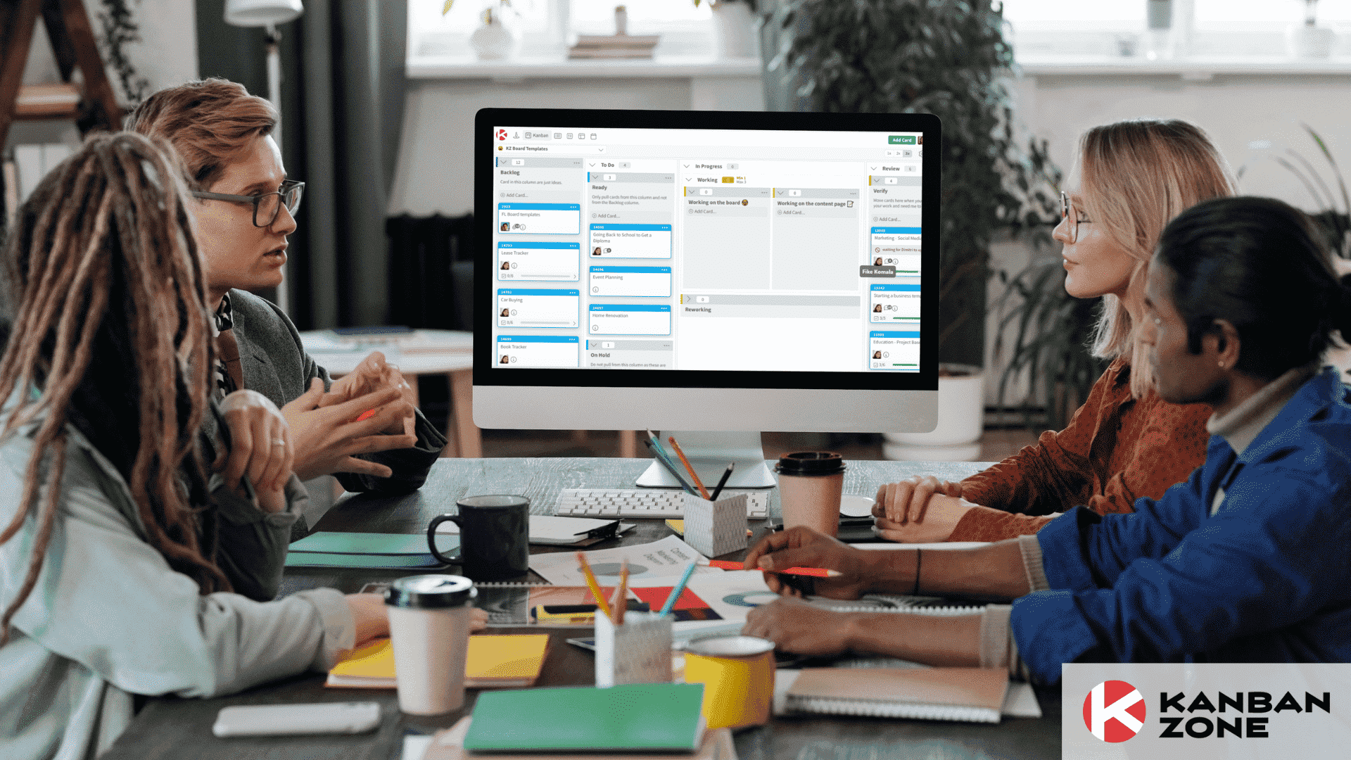 four people having a discussion in front of a computer