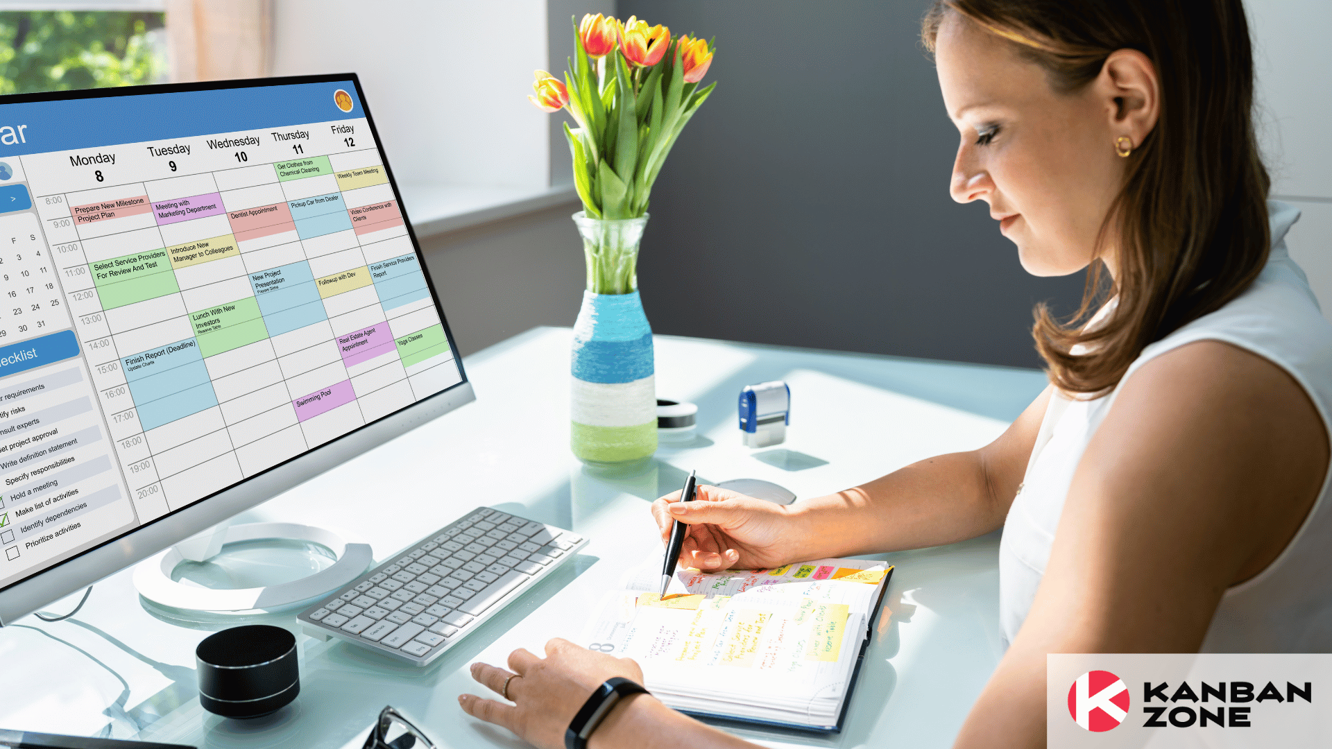 woman looking at notebook in front of a computer