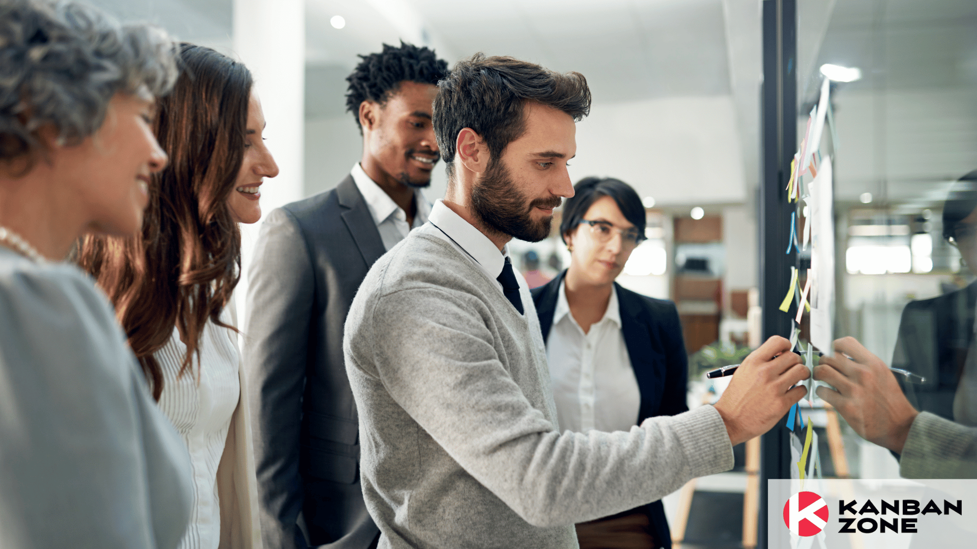 Group of businesspeople brainstorming in front of a glass wall with cards